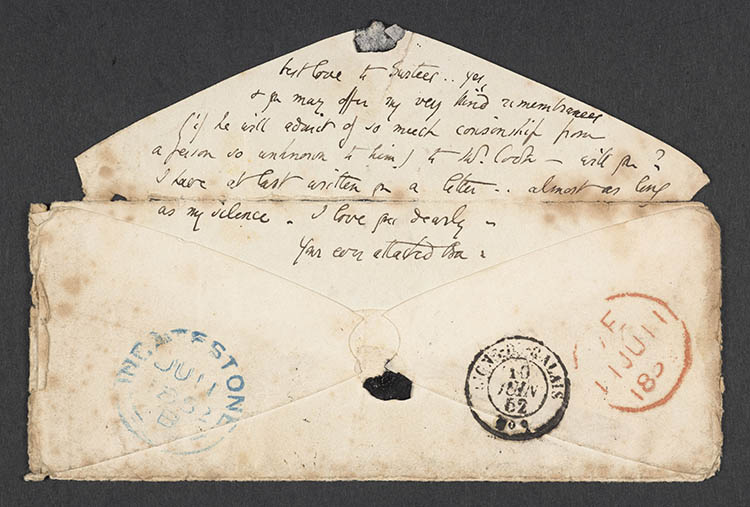 An envelope with the lines of text written on the flap and postmarks on the front