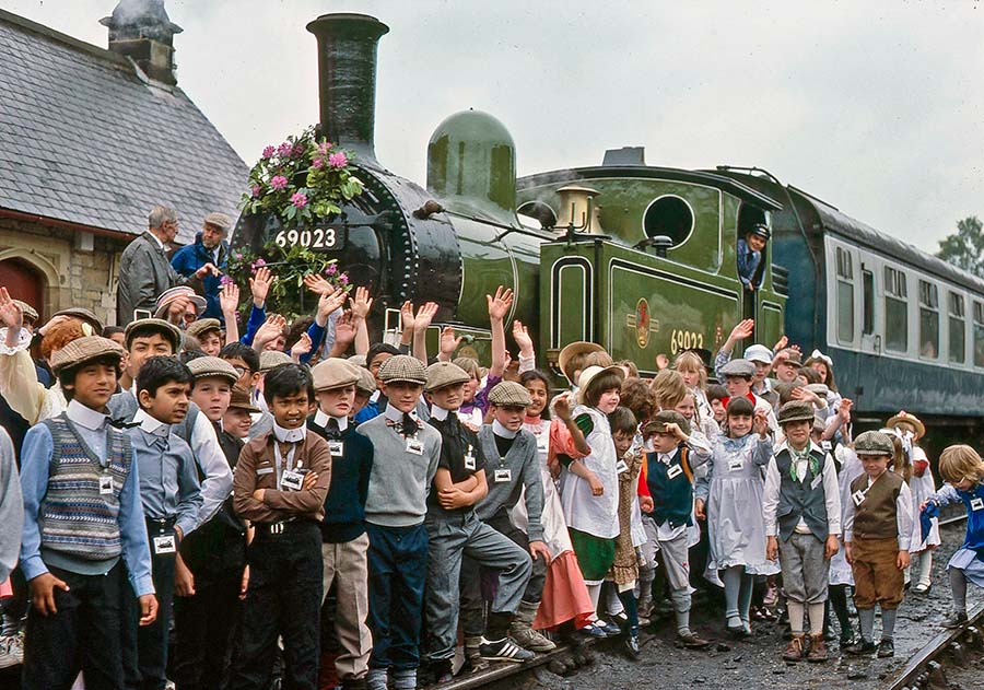 Historic photo showing children surrounding train